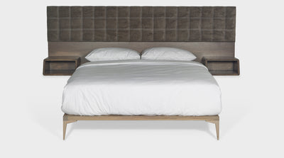 A modern contemporary bed that has a headboard made up of both mocha, block-stitched upholstery and built in oak pedestals. It also has an oak bed base, front view.