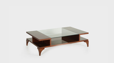 A coffee table that is a combination of both classic and modern design with a glass top and timber frame with triangular legs.