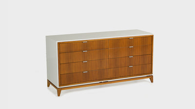 A mid-century chest of drawers with eight, walnut, drawers and slim silver handles. It has a white frame and walnut legs. 