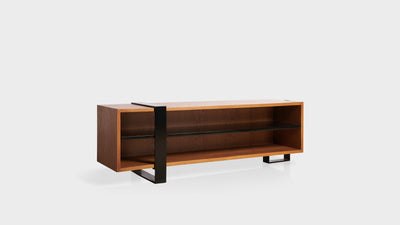 A contemporary TV unit with an industrial design. It has an oak frame, black shelf and a black, steel leg.
