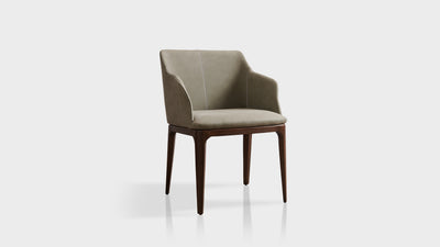 An Italian inspired contemporary dining chair which has slightly curved, high arms, diagonal back legs made of oak timber and a white cross-stitching detail that lines the tailored, leather upholstery.