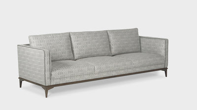 A contemporary, grey honeycomb pattern upholstered sofa with an oak base and slim arms which have a dark grey piping detail.