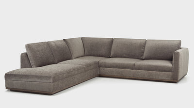 A stone grey contemporary corner sofa with an oak base, one arm and a chaise.