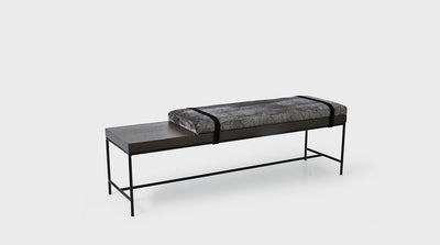 A contemporary ottoman design with an upholstered seat and timber bench detail. It also features a strap finish and black powder coated steel legs. 