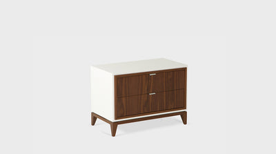 A modern pedestal with a white, painted frame, tapered, walnut legs and two walnut drawers with slim steel handles.