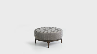 A round, mid-century ottoman with a plush, upholstered seat and oak base, with tapered legs.