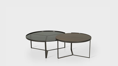 Round, nesting coffee tables with walnut and glass tops featuring gun metal grey, painted, steel bases.