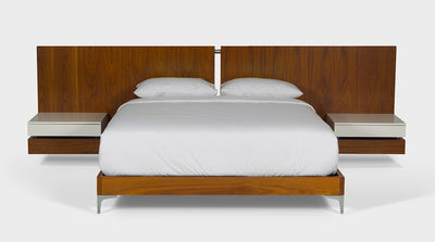 A linear, walnut timber bed with floating pedestals and silver accents, front view.