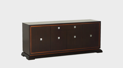 A 1975 keyboard sideboard made from dark mahogany with a natural mahogany trim and silver handles. It has drawers and cupboards.