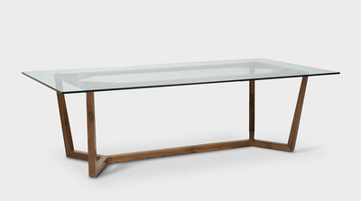 A contemporary dining table with a clear, glass, rectangular top and an oak timber base.  