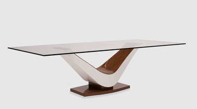 A contemporary dining table with a clear, glass, rectangular top and a dual toned, curved, timber base.