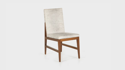 A contemporary dining chair with off-white upholstery and a walnut timber frame.