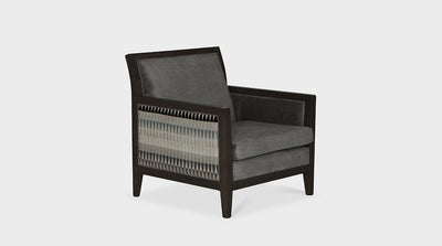 This occasional chair is a modern take on a traditional square silhouette. It has a dark mahogany frame and an upholstered seat made with grey and geometric print fabric.
