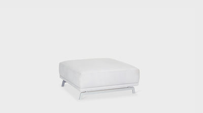 A modern, square, off-white upholstered ottoman with silver steel legs.