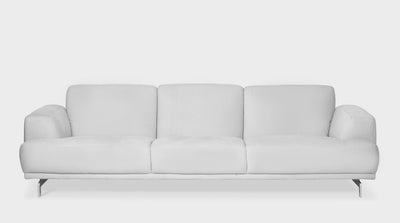 A fully upholstered, off white, modern contemporary sofa with plush cushions, wide arms and steel legs, front view.