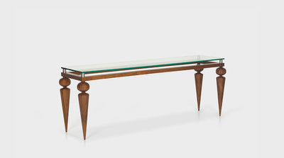 A console table that has a glass top, silver accents and a walnut base with tapered legs and round handcrafted details.