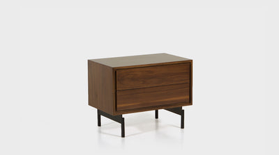 A mid-century inspired, walnut pedestal with two drawers, a shadow line detail and black, steel legs. 