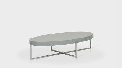 An oval, contemporary coffee table with a grey, timber top and crossed, steel legs.