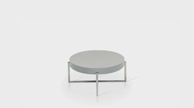 A round, contemporary coffee table with a grey, timber top and crossed, steel legs.
